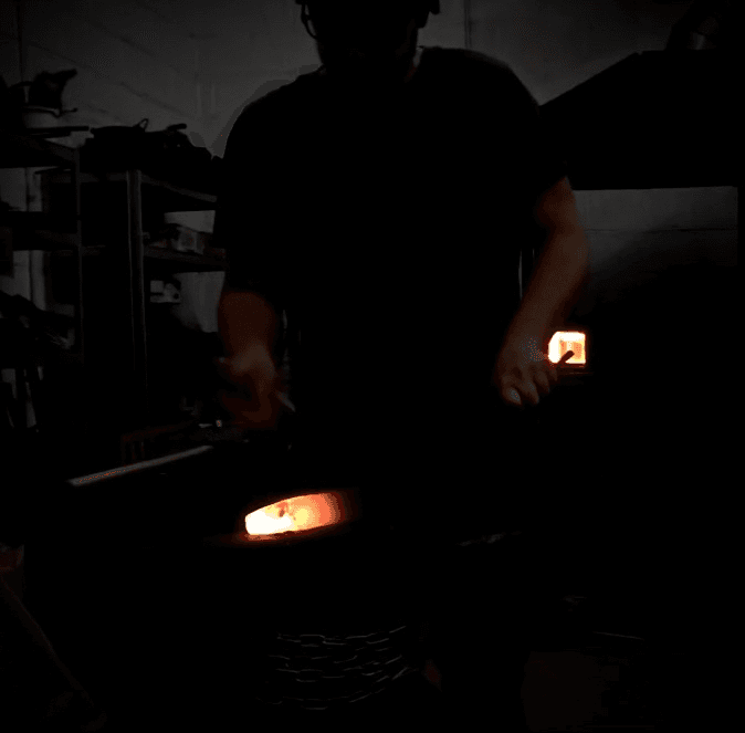 Chris working at the forge with glowing heat